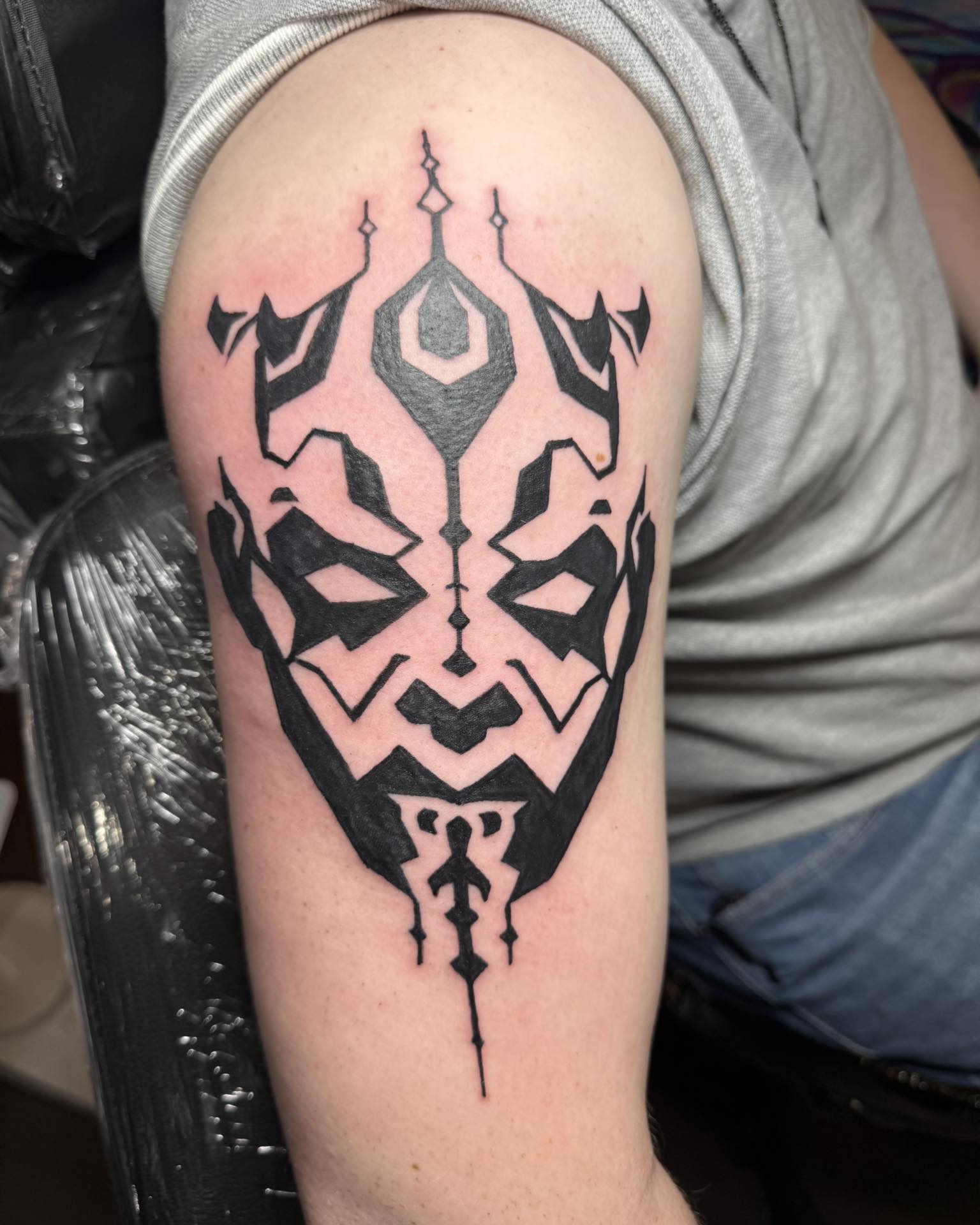 Abstract black tattoo design on upper arm in cybersigilism