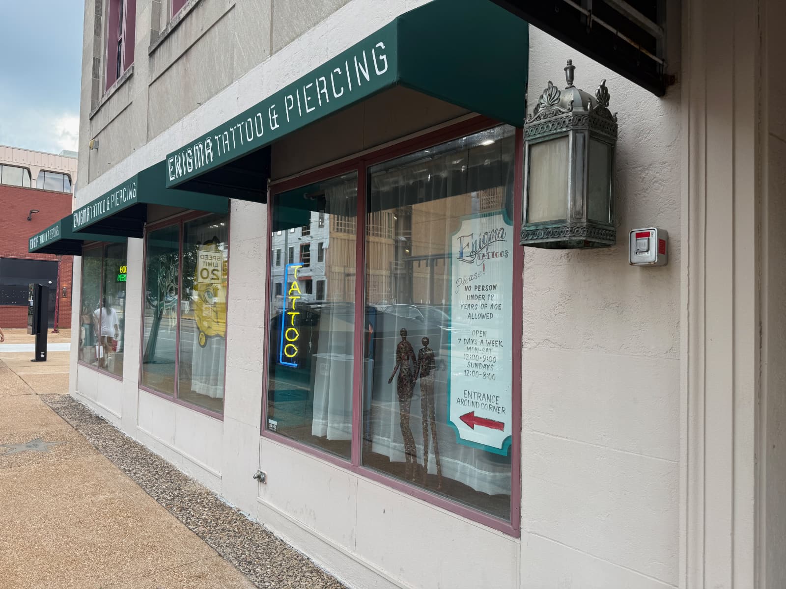 Enigma Tattoo & Piercing storefront with neon sign.