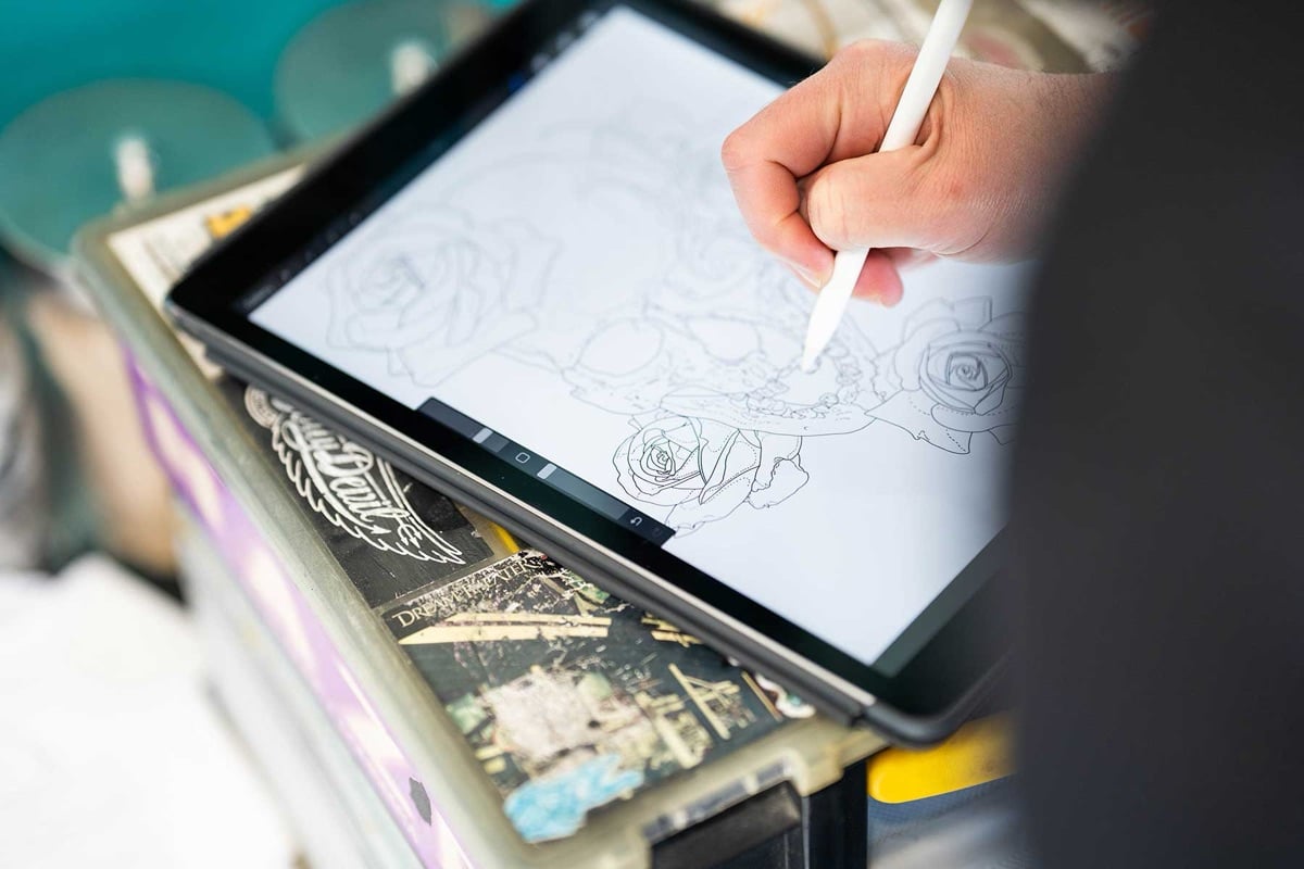 Enigma artist sketching a custom tattoo design on an iPad